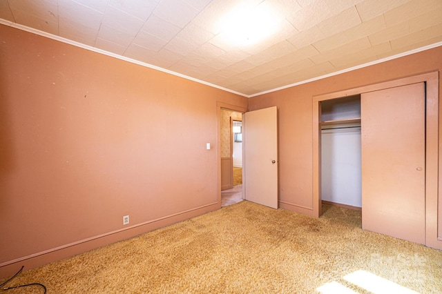 unfurnished bedroom featuring carpet flooring, a closet, and ornamental molding