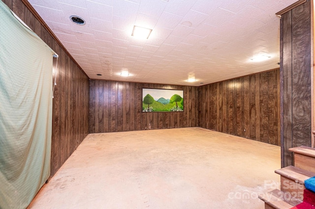 finished below grade area featuring wooden walls and stairs