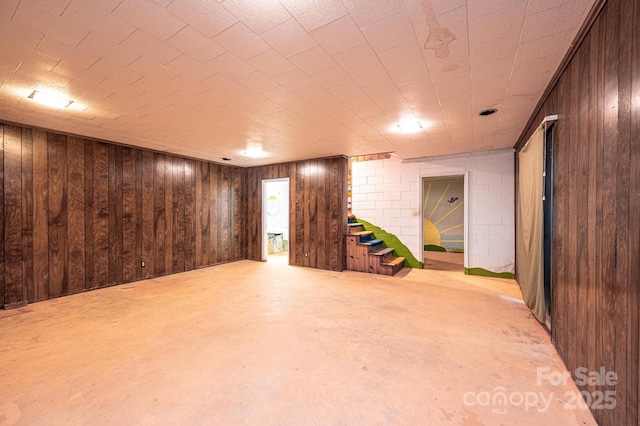 finished below grade area featuring wooden walls and stairs