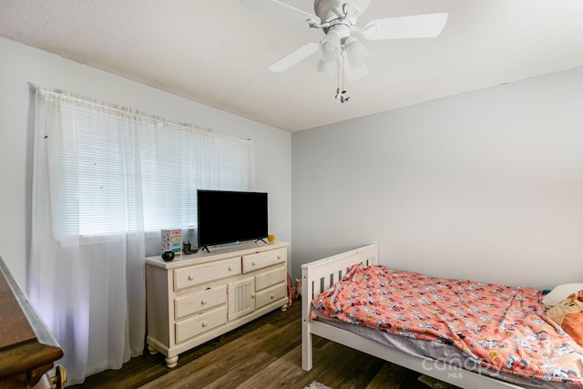 bedroom featuring a ceiling fan and dark wood-style flooring