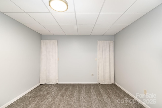 carpeted spare room with baseboards and a paneled ceiling
