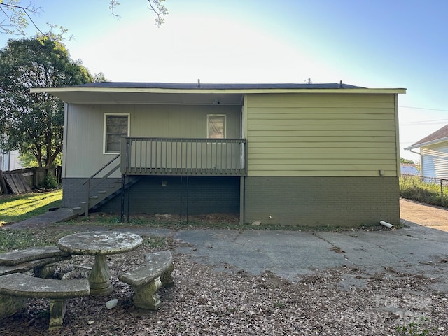 back of house featuring stairway and fence