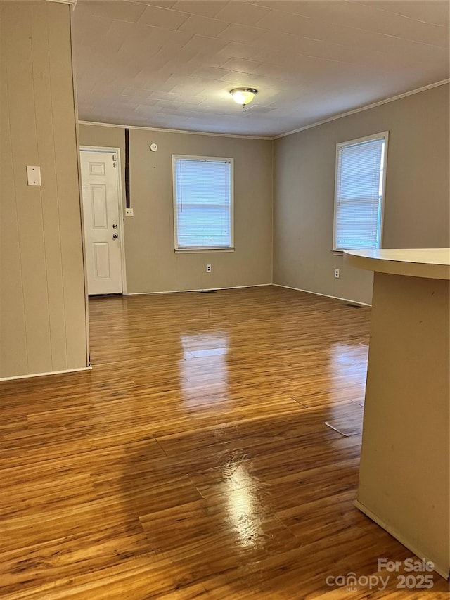 spare room featuring crown molding and wood finished floors