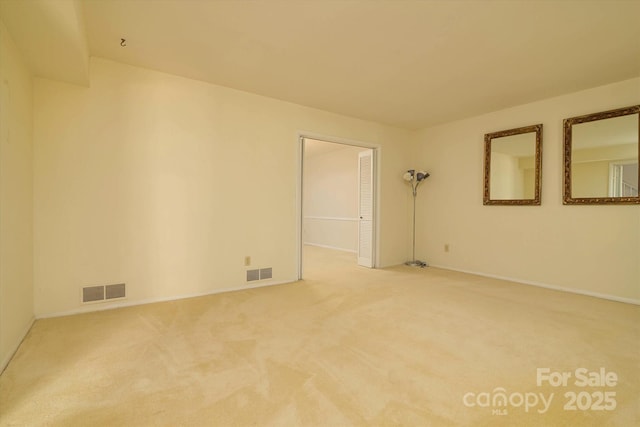 unfurnished room with visible vents, baseboards, and carpet flooring