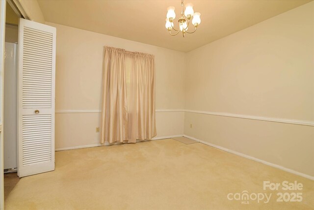 unfurnished bedroom with a closet, baseboards, carpet flooring, and a notable chandelier