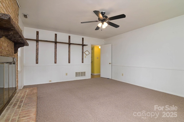 carpeted spare room featuring visible vents and a ceiling fan