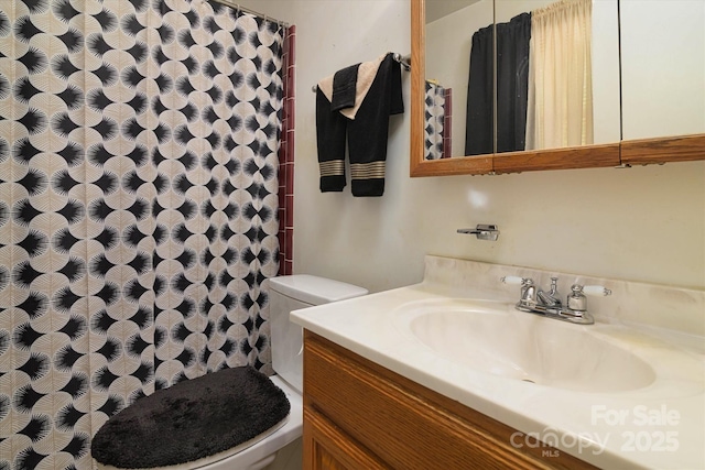 full bathroom with curtained shower, vanity, and toilet