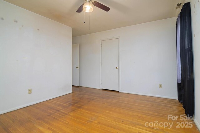 unfurnished room featuring visible vents, ceiling fan, light wood-type flooring, and baseboards