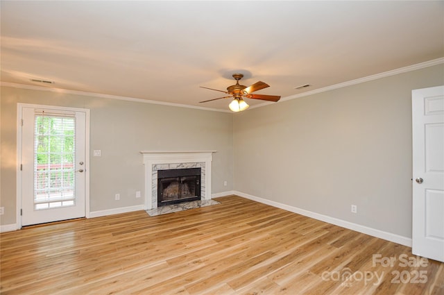 10805 Winterbourne Ct, Charlotte, NC 28277 - unfurnished living room featuring crown molding, ceiling fan, light wood-style flooring, visible vents, and a high end fireplace