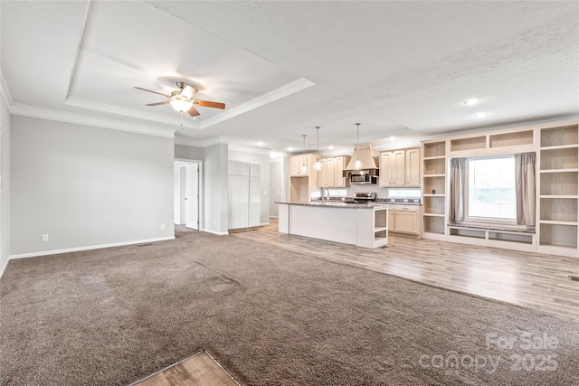 unfurnished living room featuring ornamental molding, recessed lighting, ceiling fan, a tray ceiling, and baseboards