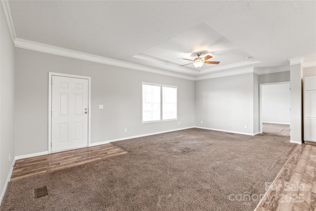 interior space with baseboards, ornamental molding, a tray ceiling, and a ceiling fan