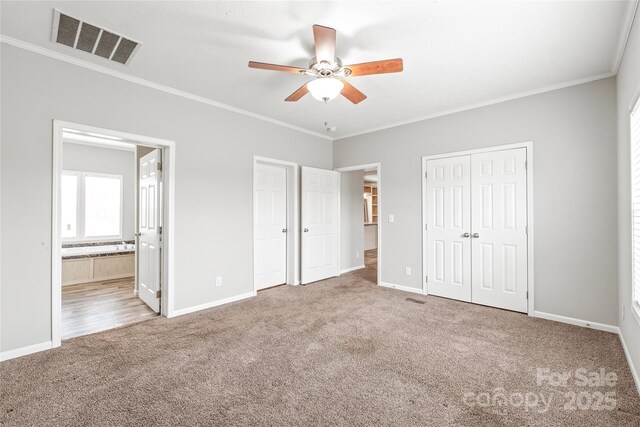 unfurnished bedroom featuring carpet flooring, visible vents, baseboards, and ornamental molding