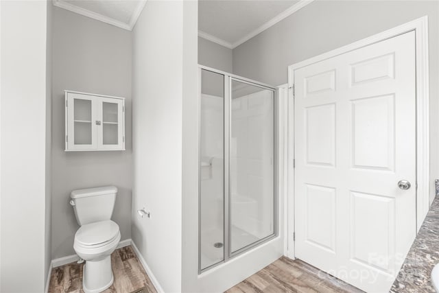 full bath with toilet, wood finished floors, a stall shower, baseboards, and ornamental molding