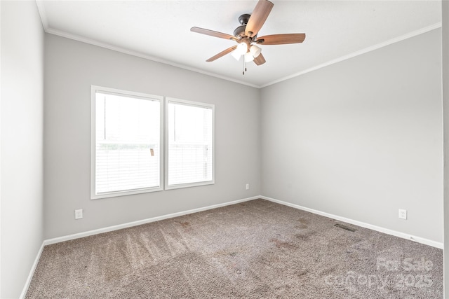 empty room featuring ceiling fan, ornamental molding, carpet flooring, and baseboards