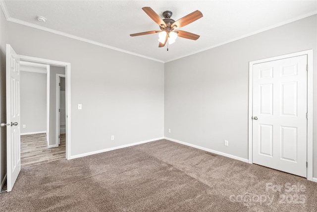 unfurnished bedroom featuring ceiling fan, carpet, baseboards, and ornamental molding