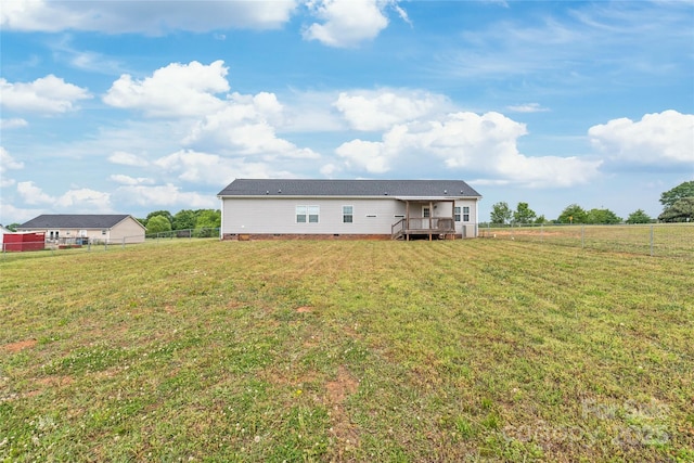 rear view of house featuring fence, crawl space, a deck, and a lawn