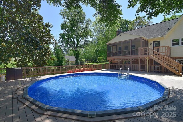 6008 Corkstone Dr, Mint Hill, NC 28227 - swimming pool featuring a sunroom, a wooden deck, and stairs