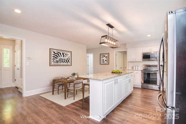 6008 Corkstone Dr, Mint Hill, NC 28227 - kitchen featuring stainless steel appliances, white cabinets, a center island, wood finished floors, and baseboards