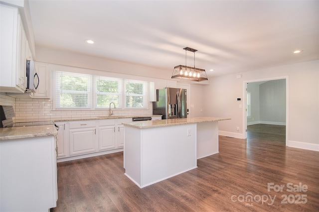 6008 Corkstone Dr, Mint Hill, NC 28227 - kitchen with appliances with stainless steel finishes, a sink, a kitchen island, tasteful backsplash, and recessed lighting