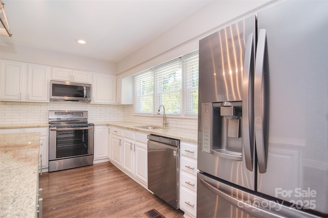 6008 Corkstone Dr, Mint Hill, NC 28227 - kitchen with appliances with stainless steel finishes, a sink, white cabinets, tasteful backsplash, and dark wood finished floors