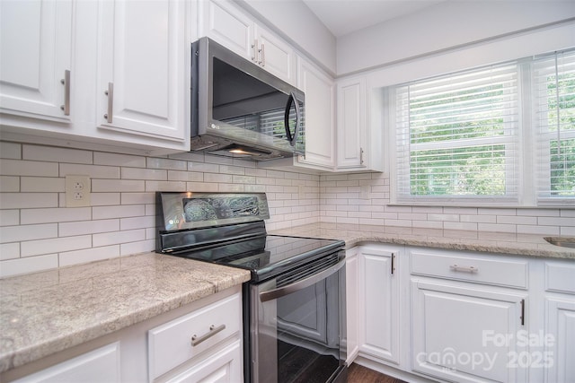 6008 Corkstone Dr, Mint Hill, NC 28227 - kitchen featuring stainless steel microwave, electric stove, white cabinetry, and backsplash