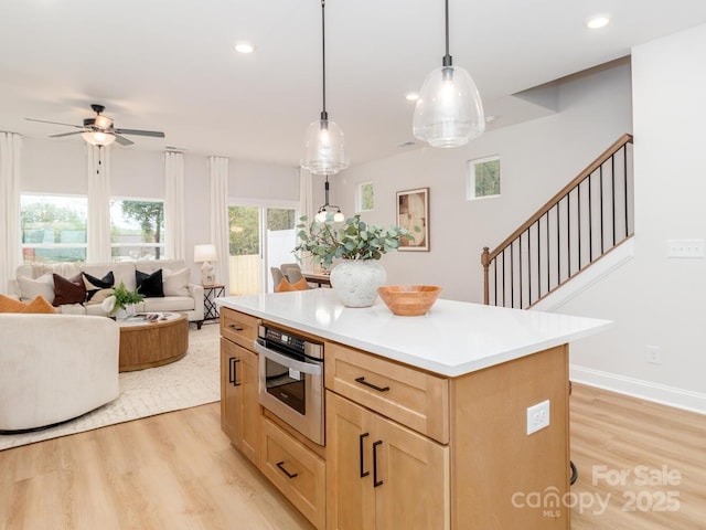 kitchen with light brown cabinets, oven, light wood-style floors, a ceiling fan, and recessed lighting