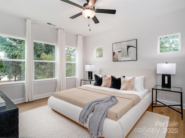 bedroom featuring light wood-style flooring, baseboards, and a ceiling fan