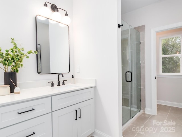full bathroom featuring a shower stall, vanity, and baseboards