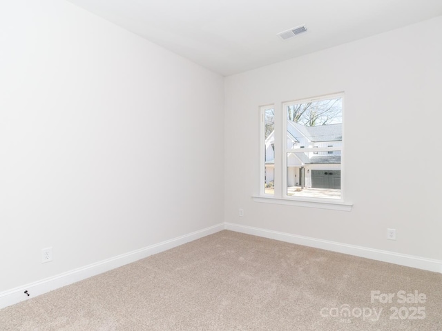 carpeted spare room featuring baseboards