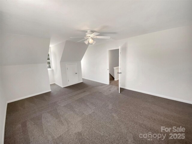 bonus room with dark colored carpet, baseboards, and a ceiling fan