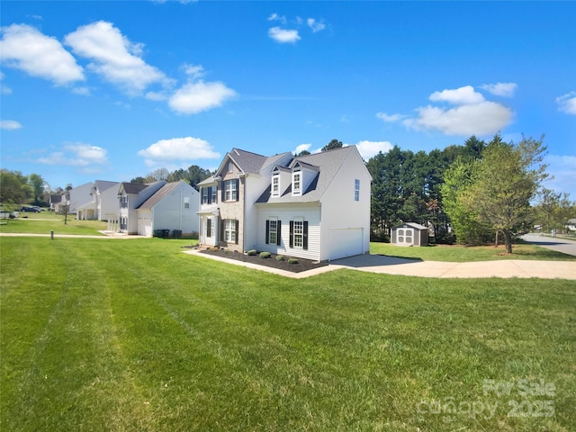 rear view of house featuring an attached garage, driveway, a residential view, and a lawn
