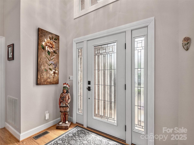 entrance foyer with visible vents, light wood-style flooring, and baseboards