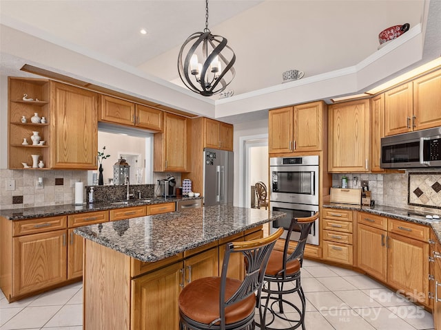 kitchen featuring appliances with stainless steel finishes, light tile patterned floors, tasteful backsplash, and a center island