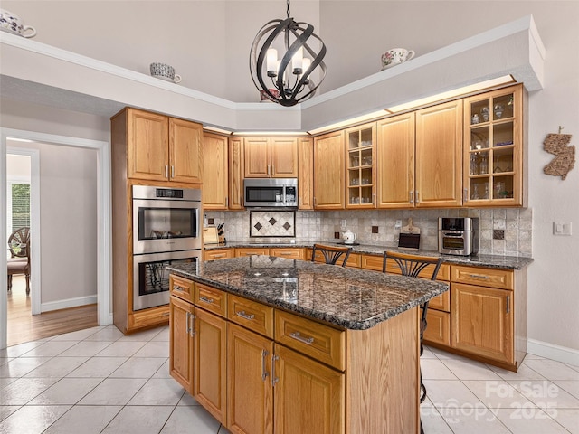 kitchen featuring light tile patterned floors, tasteful backsplash, appliances with stainless steel finishes, and baseboards