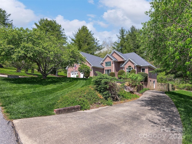 view of front of property with a front yard, driveway, and fence
