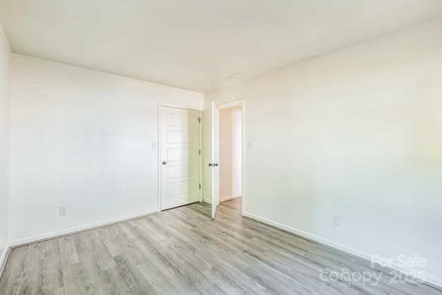 unfurnished room with baseboards and wood finished floors