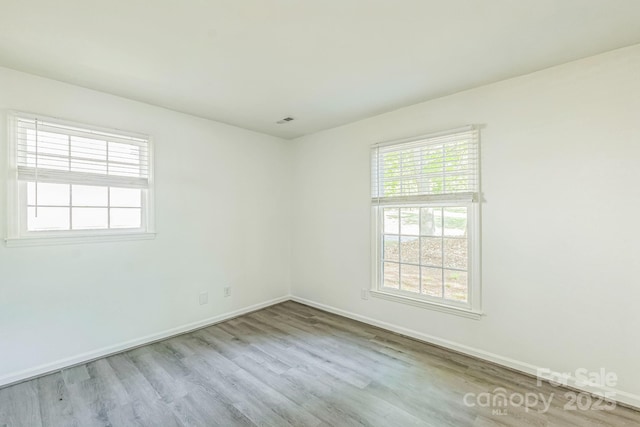 unfurnished room featuring baseboards and wood finished floors