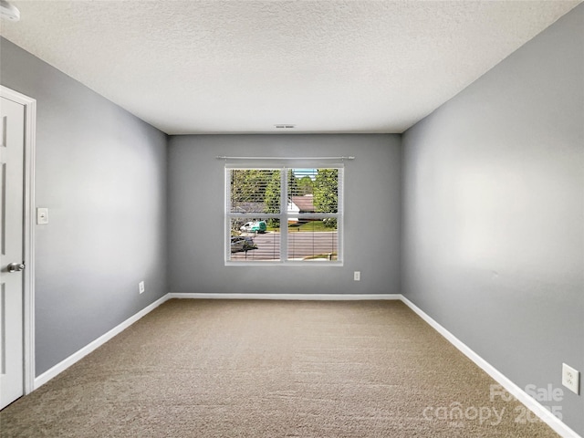 unfurnished room featuring carpet floors, baseboards, and a textured ceiling