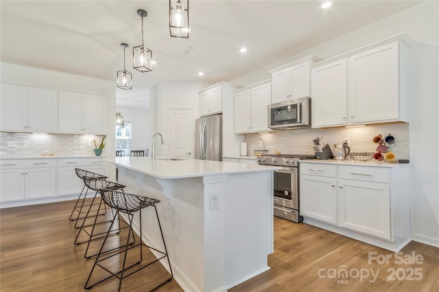 14224 Canemeadow Dr, Charlotte, NC 28278 - kitchen with appliances with stainless steel finishes, a sink, decorative backsplash, recessed lighting, and a center island with sink