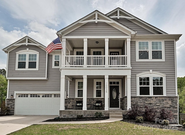 10035 Mast Cove Ln, Charlotte, NC 28278 - craftsman-style home featuring a balcony, a porch, stone siding, an attached garage, and concrete driveway