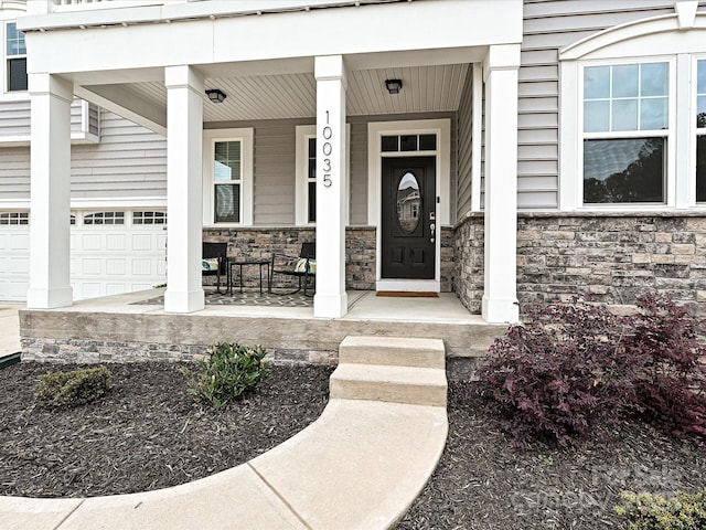 10035 Mast Cove Ln, Charlotte, NC 28278 - entrance to property featuring a porch, stone siding, and a garage