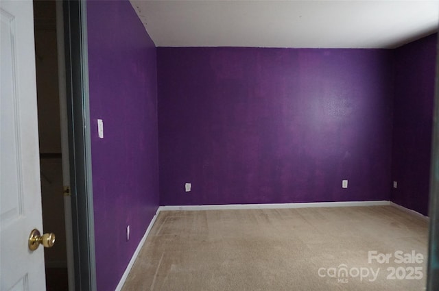 empty room featuring baseboards and carpet flooring