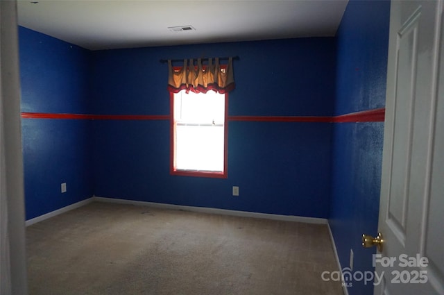 unfurnished room featuring baseboards, visible vents, and carpet