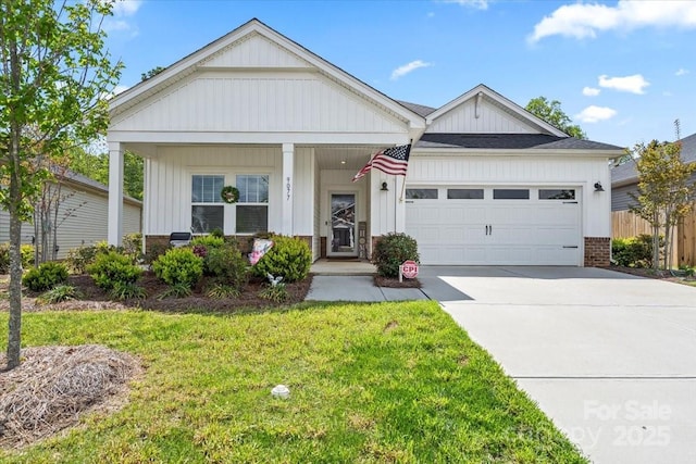 view of front of house featuring a garage, concrete driveway, fence, a front yard, and brick siding