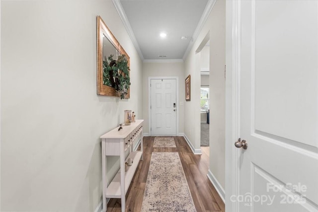 interior space with baseboards, light wood-style floors, and ornamental molding