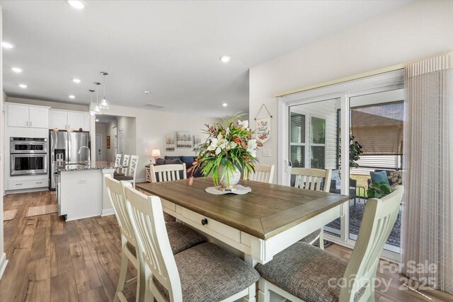 dining area with wood finished floors and recessed lighting