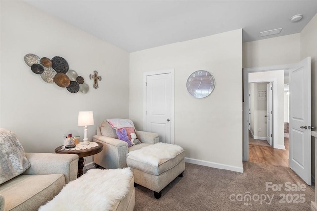 living area featuring visible vents, baseboards, and carpet