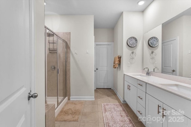 bathroom with tile patterned floors, a sink, and a stall shower