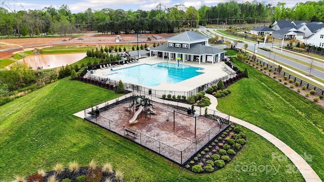 community pool featuring fence, a yard, and a patio