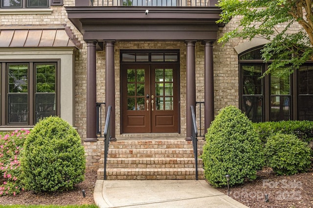 property entrance with french doors and a standing seam roof